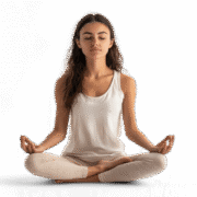 Relaxed young woman practicing meditation in a seated yoga pose with eyes closed against black background.